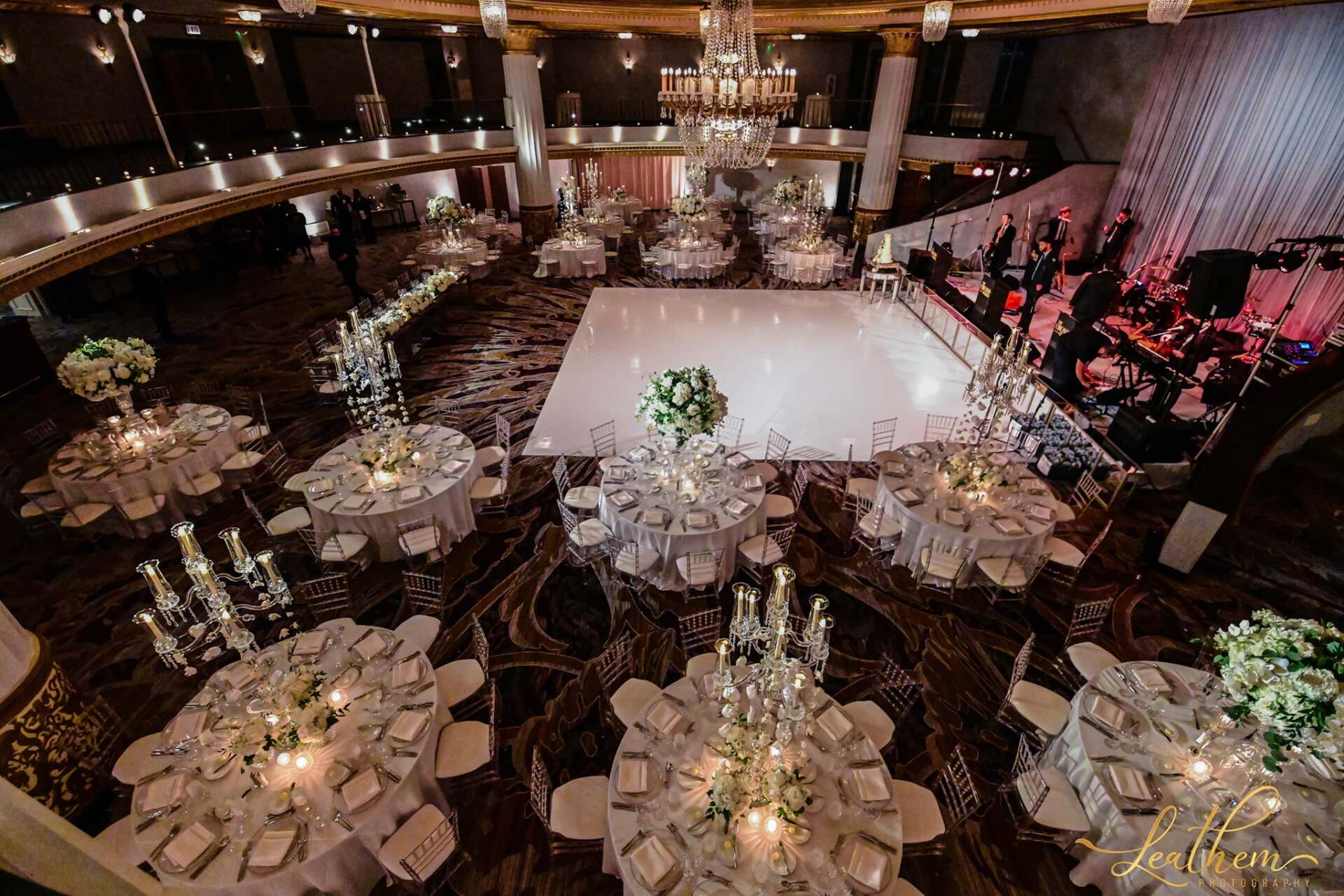 A large room with tables and chairs set up for a wedding reception.