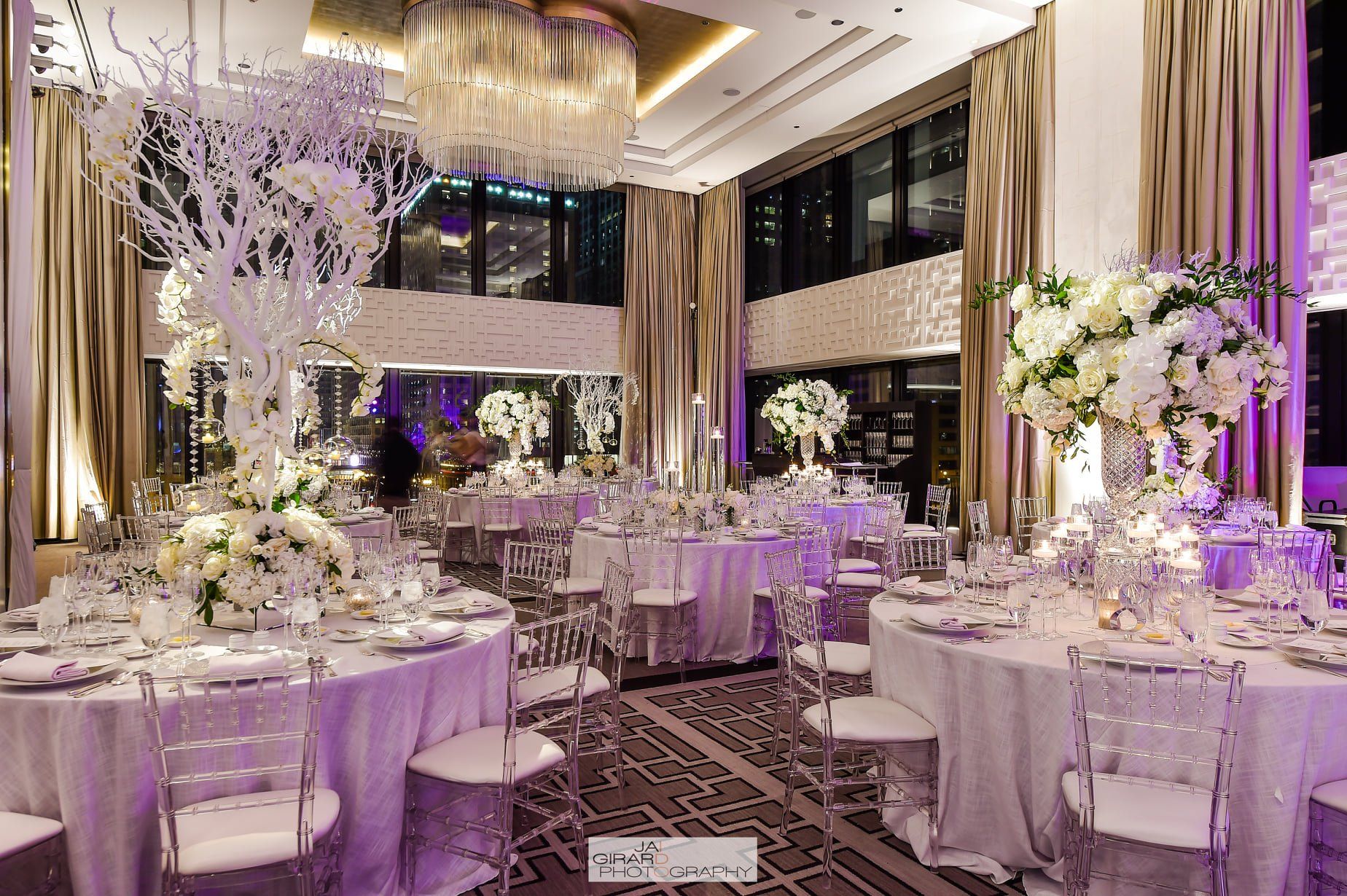 A large room with tables and chairs set up for a wedding reception.