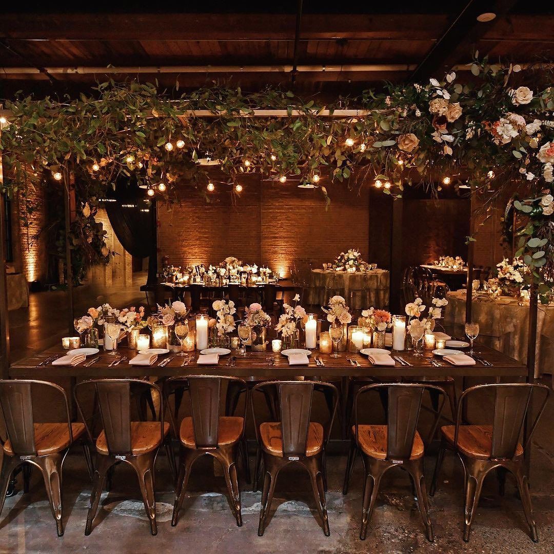 A long table with candles and flowers on it in a room.