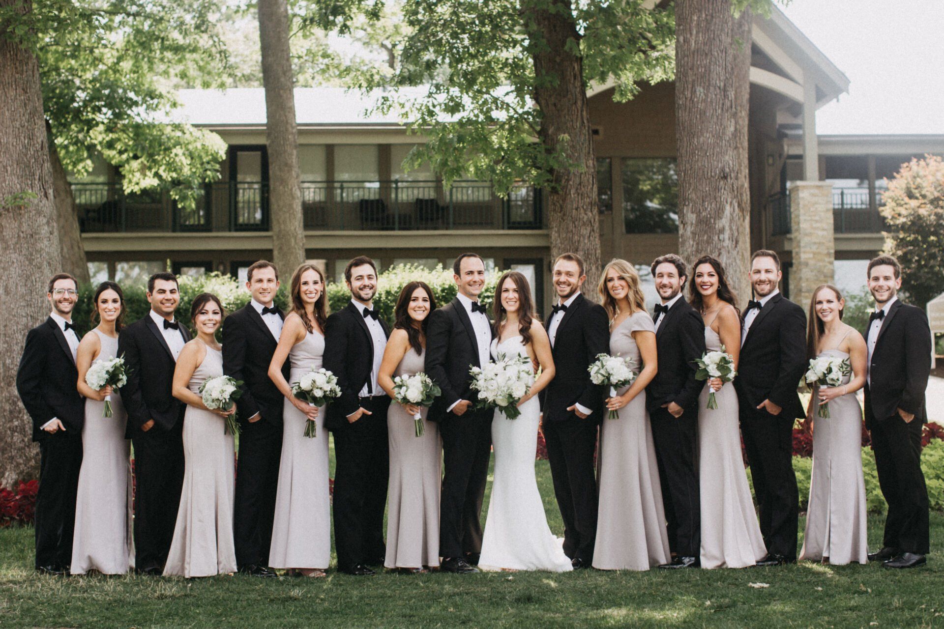 The bride and groom are posing for a picture with their wedding party.