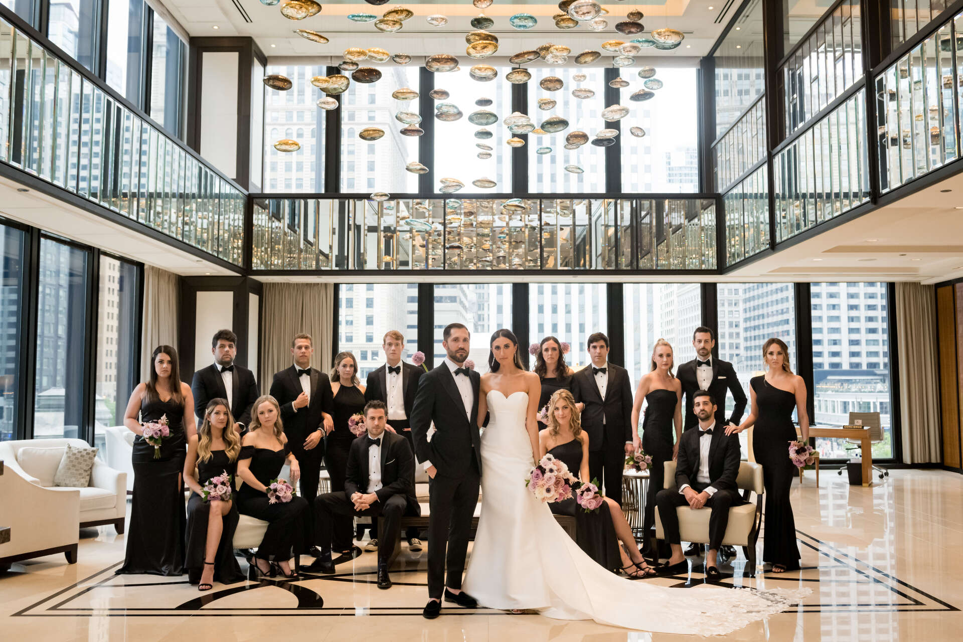 A bride and groom are posing for a picture with their wedding party.