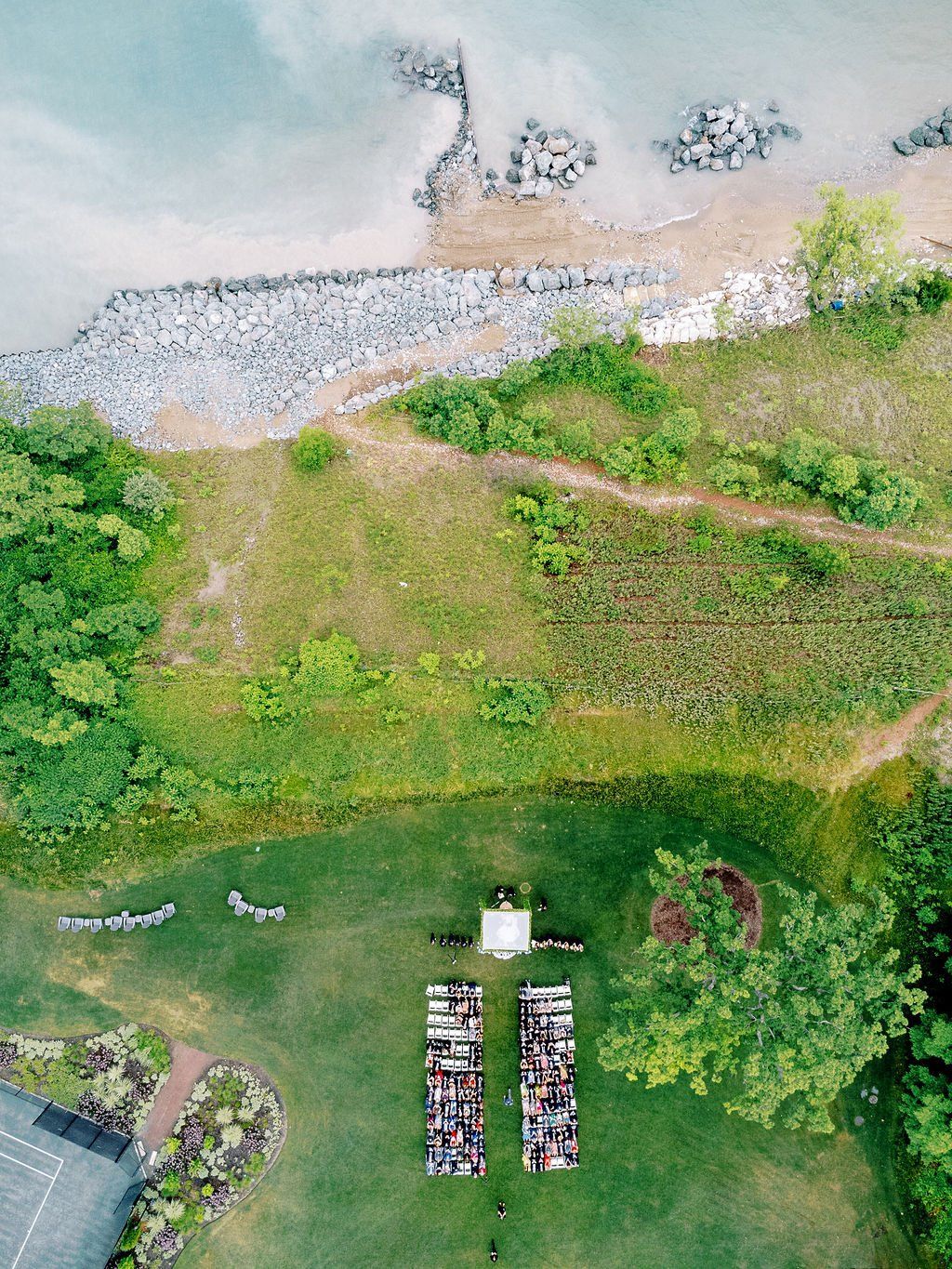 An aerial view of a wedding ceremony in a field near the ocean.