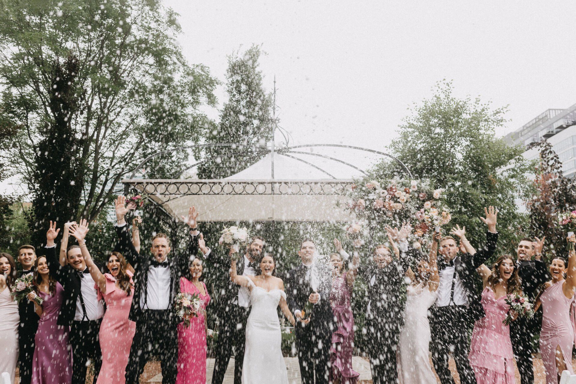 A large group of people are posing for a picture at a wedding.