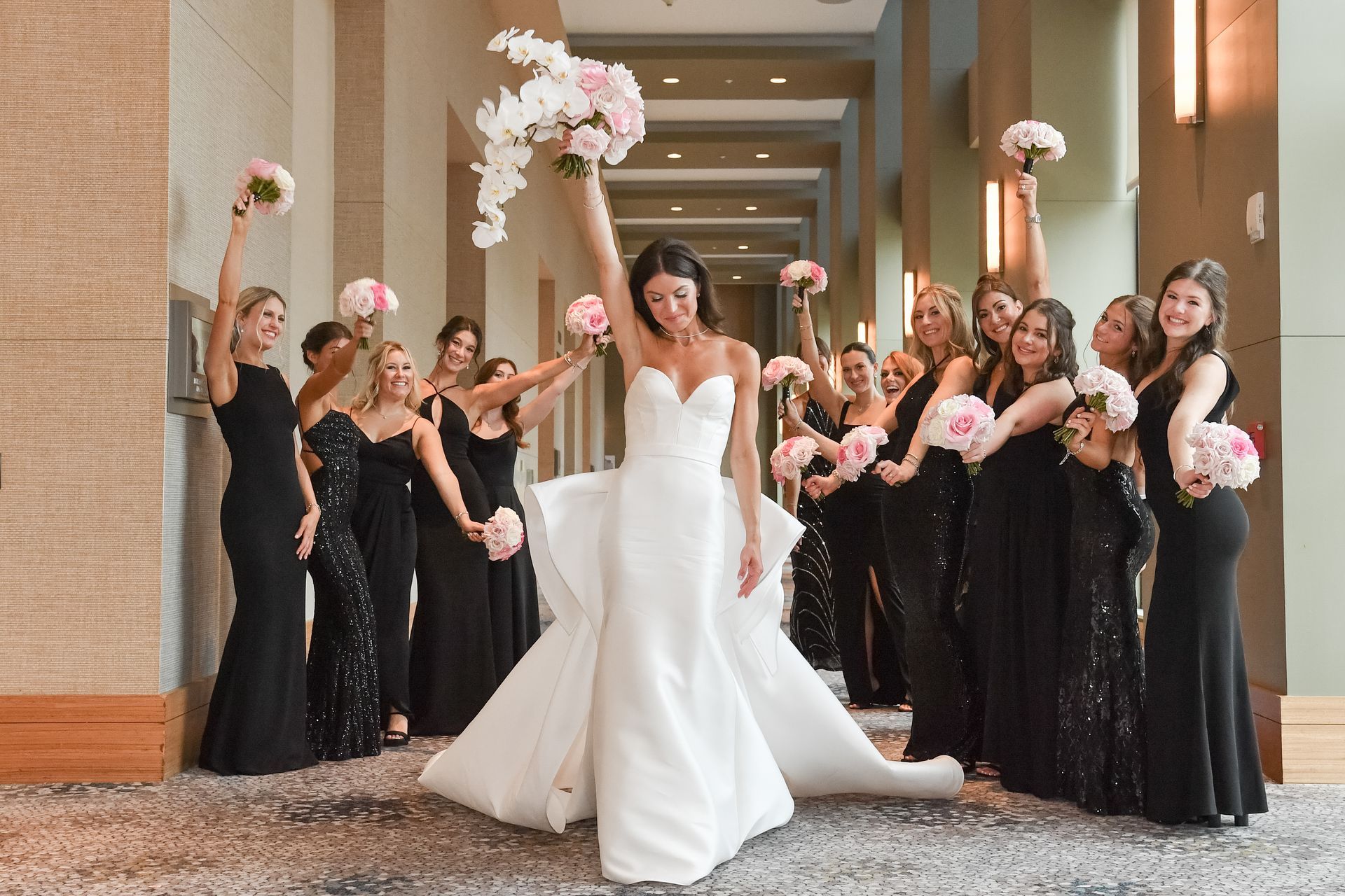 A bride and her bridesmaids are posing for a picture in a hallway.