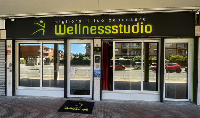 Studio di Pilates con reformer blu e altre attrezzature per esercizi in una stanza luminosa.