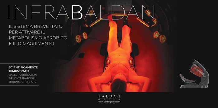 Una persona è sdraiata in un dispositivo dimagrante Infrabaldan sotto una luce rossa,