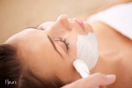Une femme reçoit un soin du visage dans un spa.
