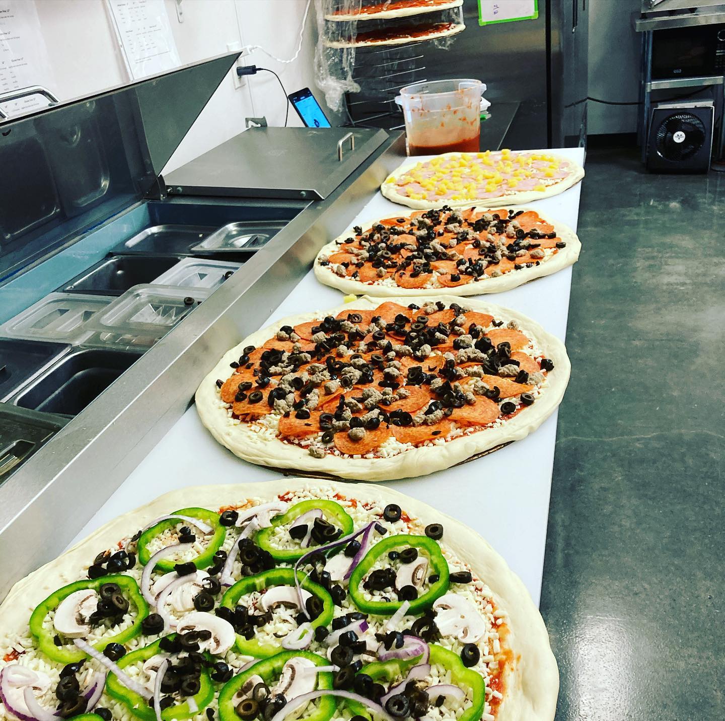 Four raw pizzas.