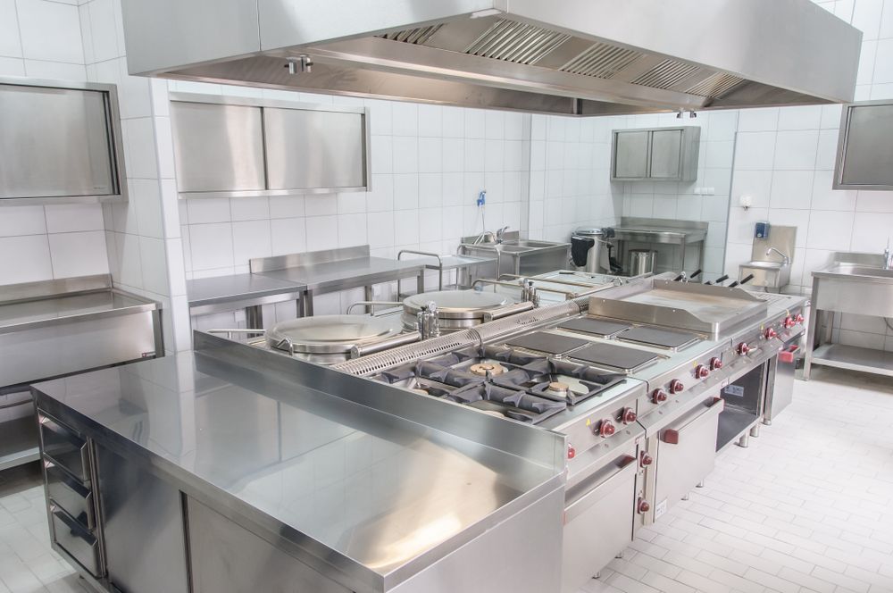 A Dishwasher is Filled With Plates and Cups in a Kitchen — Commercial Kitchens Direct in Unanderra, NSW