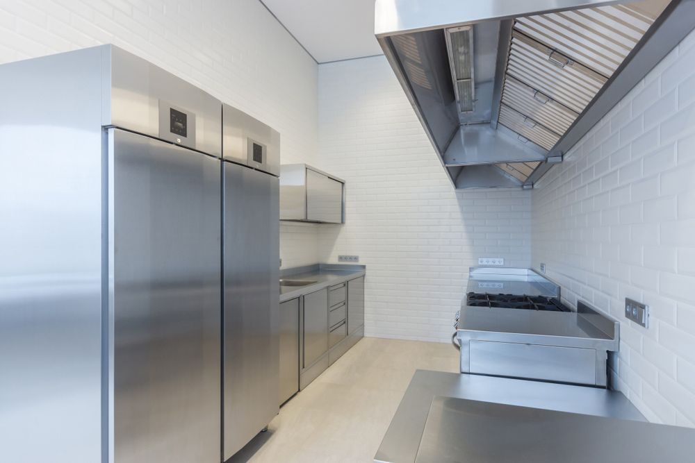 A Kitchen With Stainless Steel Appliances and White Tiles — Commercial Kitchens Direct in Unanderra, NSW