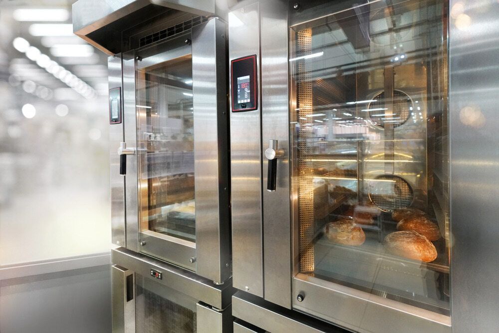 A Person is Opening a Microwave Oven in a Kitchen — Commercial Kitchens Direct in Unanderra, NSW