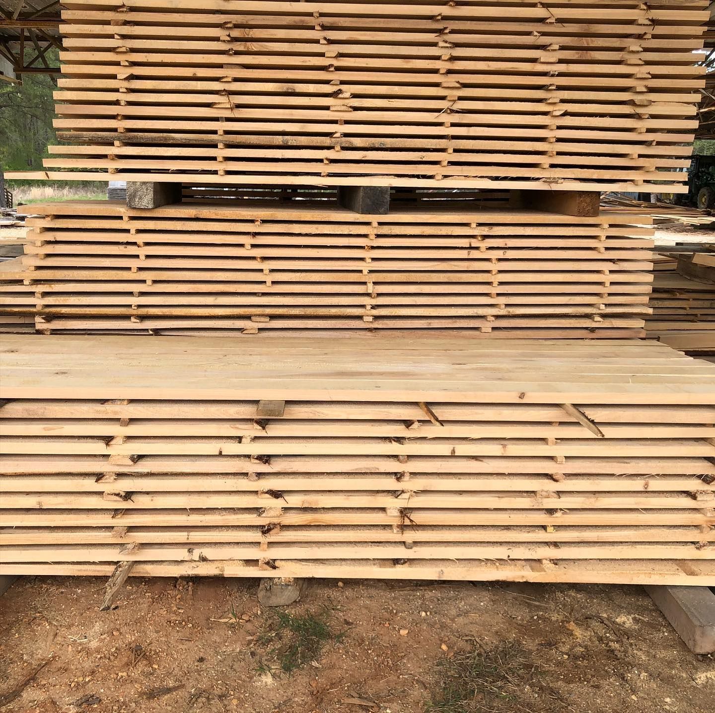 A stack of wooden boards sitting on top of each other on the ground.