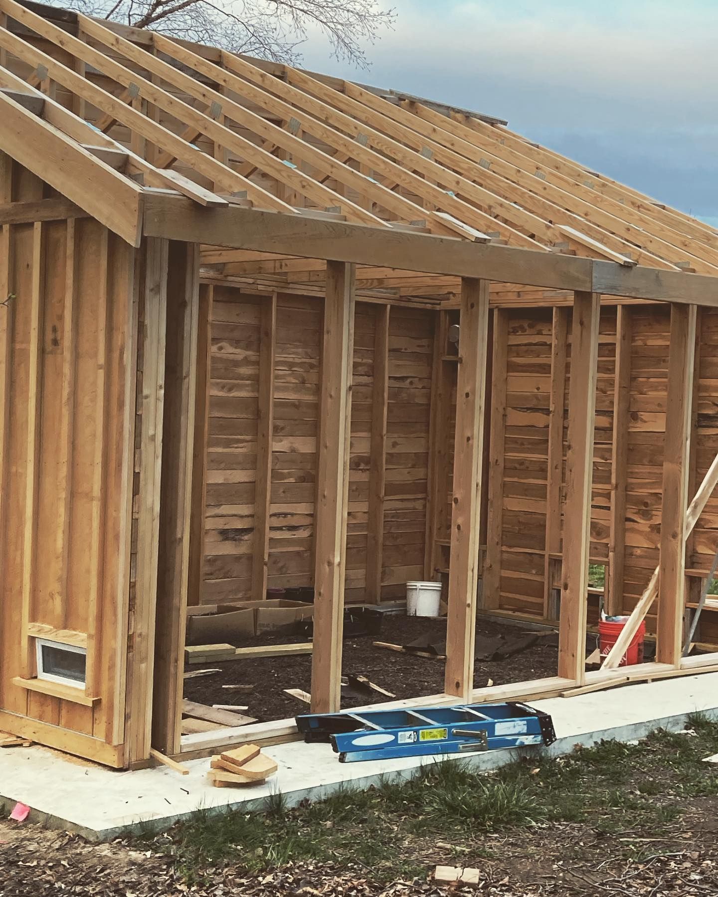 A wooden structure is being built with a ladder in the foreground. A wooden structure is being built with a ladder in the foreground.