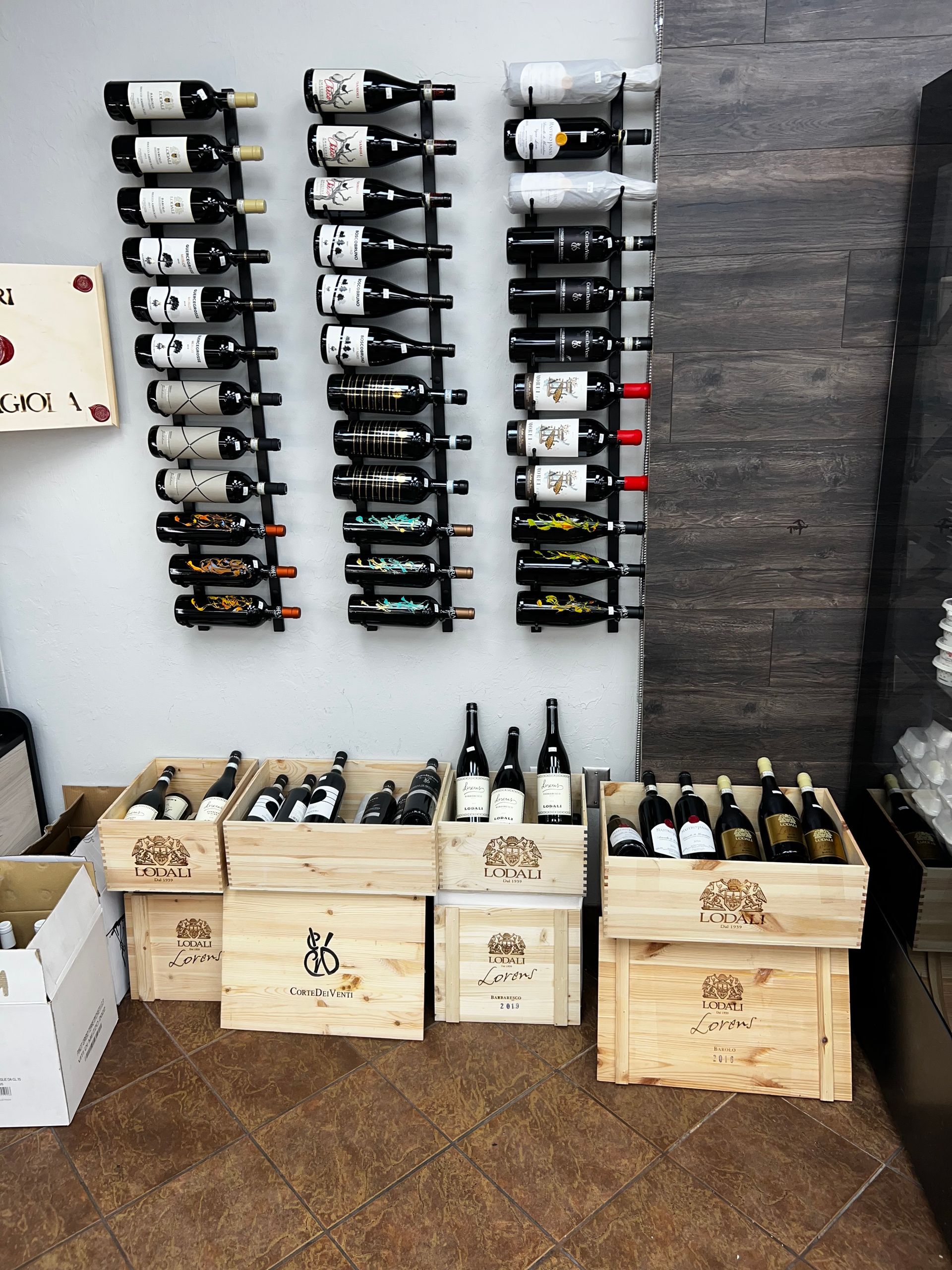 A bunch of wine bottles are lined up on a wall