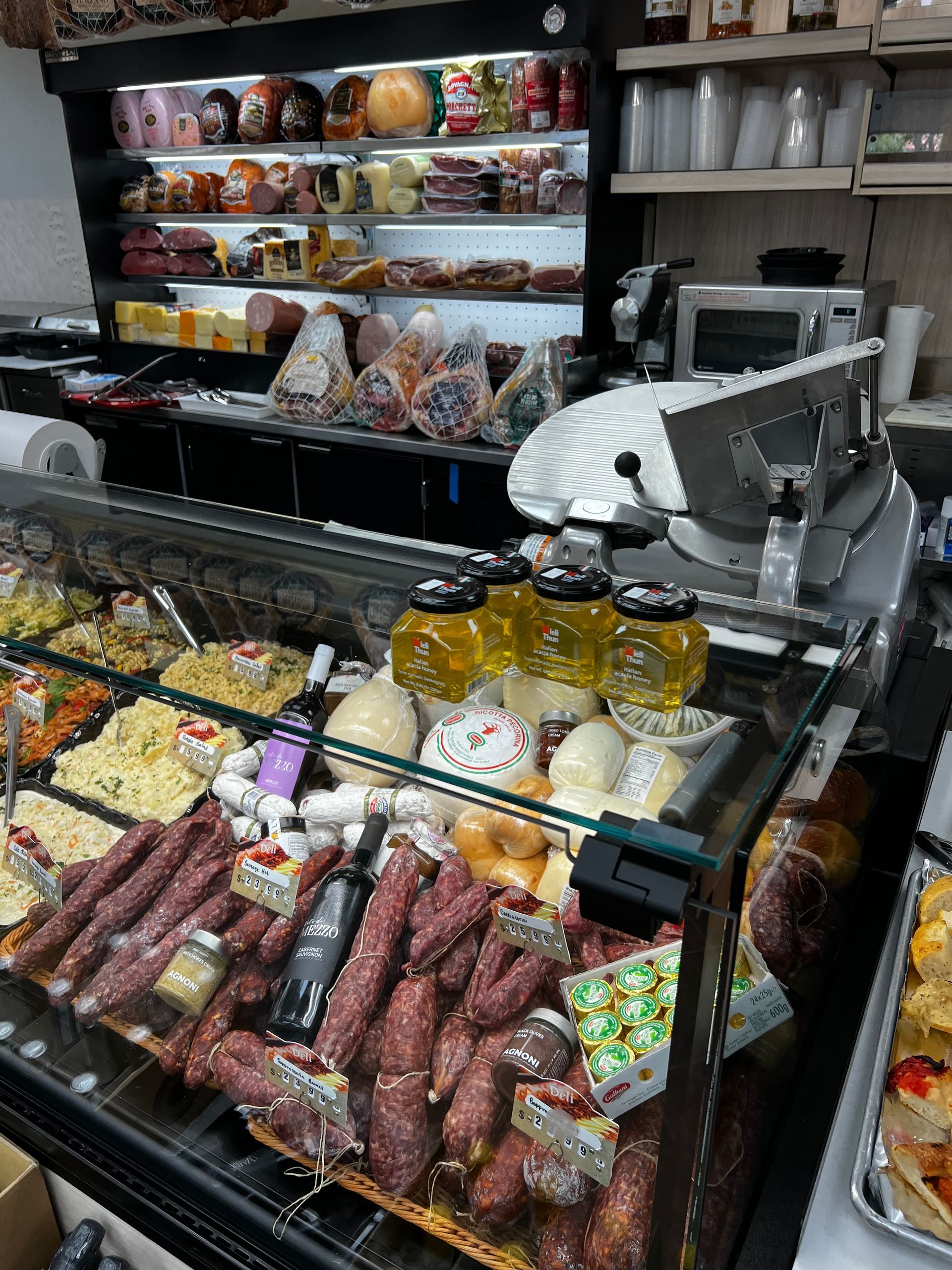 A display case filled with meats and cheeses in a store.