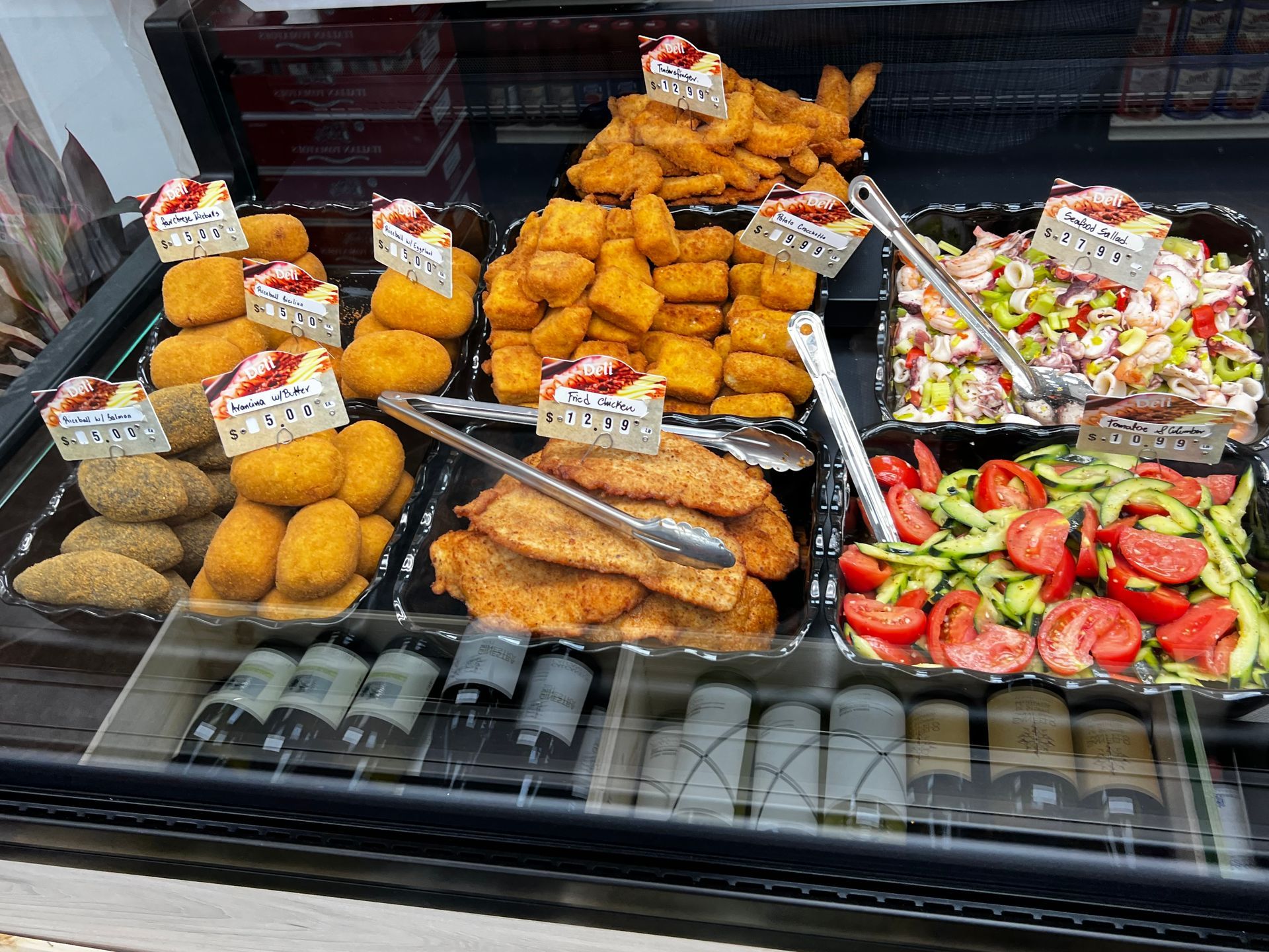 A variety of food is displayed in a glass case.