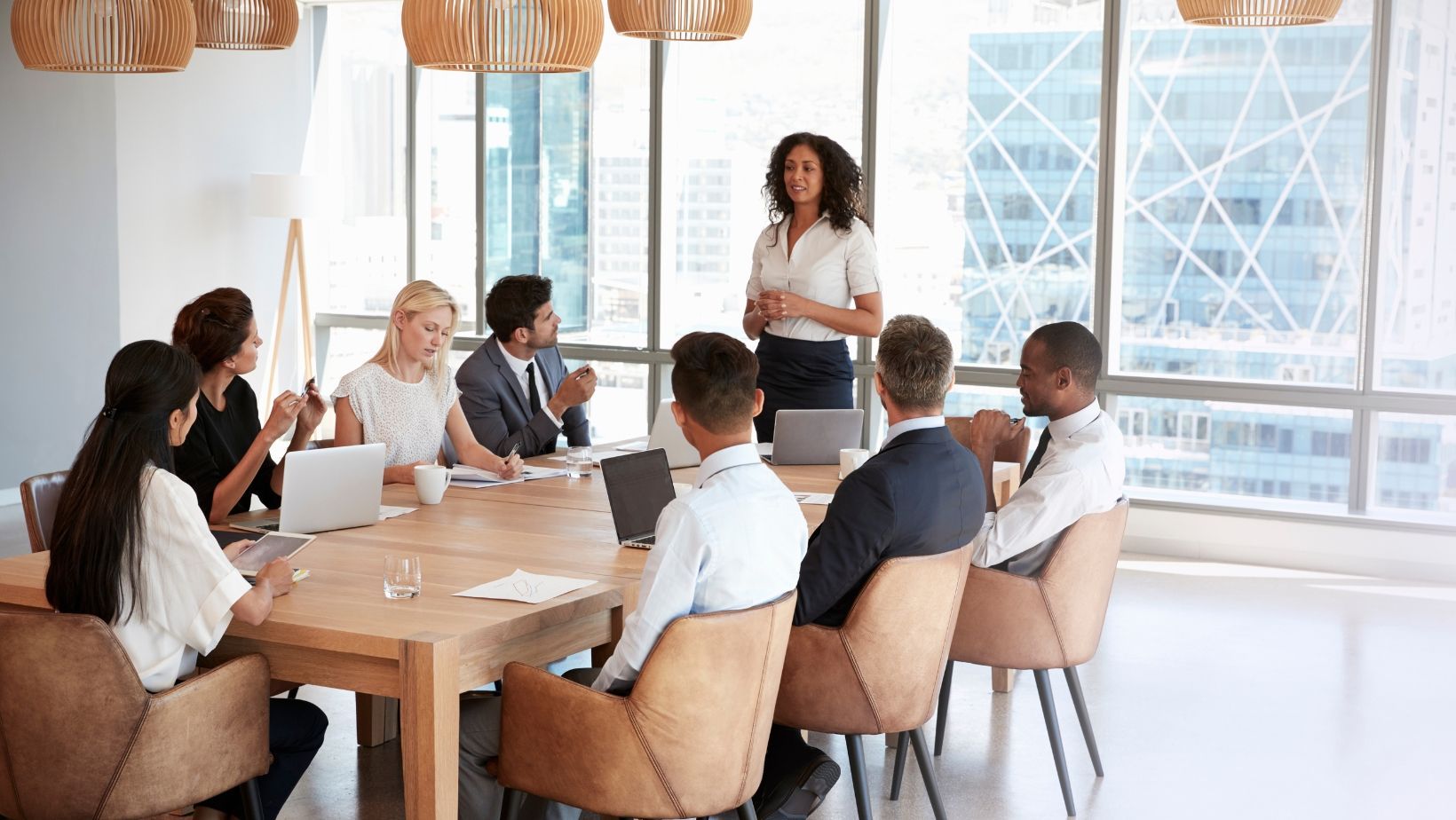 A group of people are sitting around a table having a meeting.