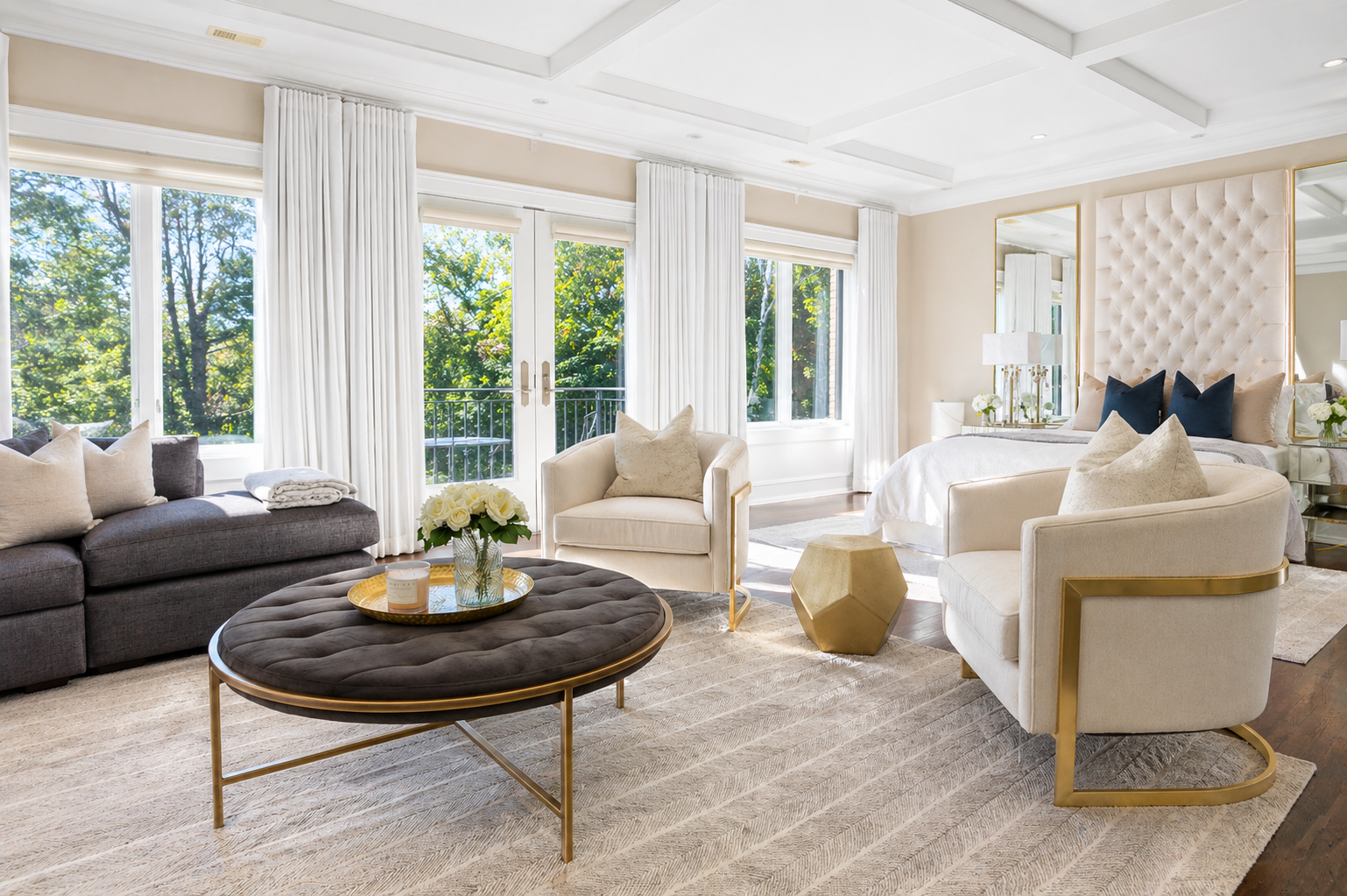 Elegant dining room with a long table, cream chairs, chandeliers, and large windows with dark curtains