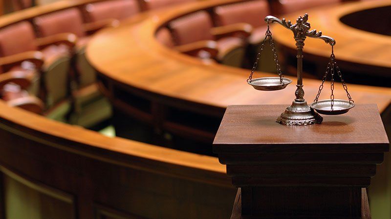 Justice scale with courtroom in the background