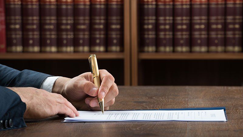 Man writing on paper in an office or library