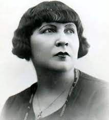 Een zwart-witfoto van een vrouw met kort haar en een ketting.