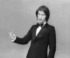 Een zwart-witfoto van een man in een smoking en vlinderdas.