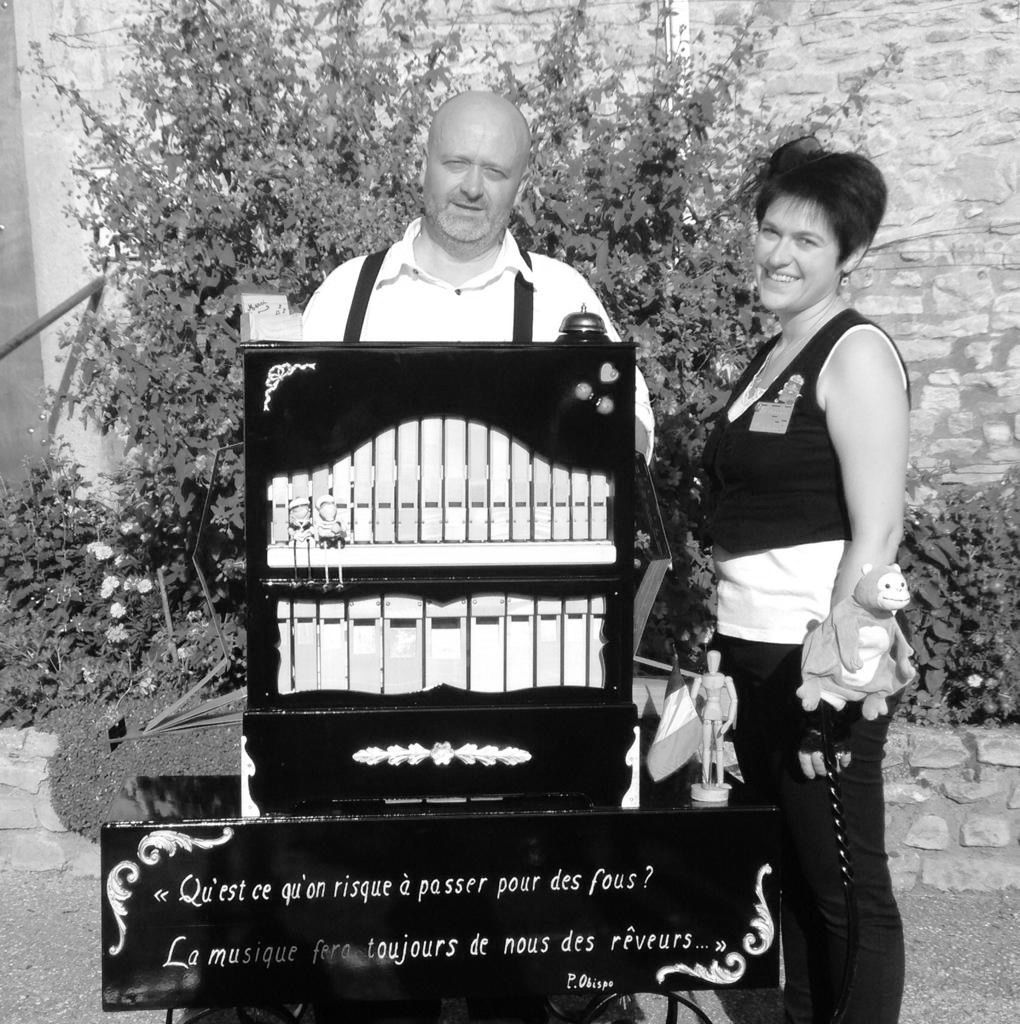 Een zwart-witfoto van een man en vrouw die naast een orgel staan
