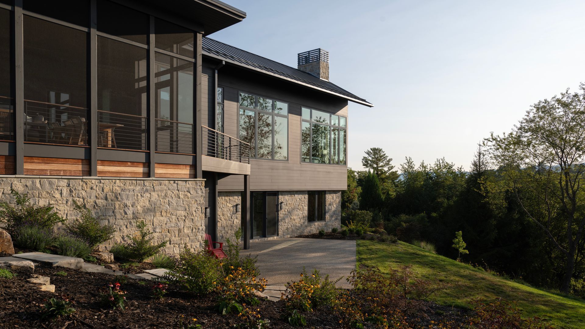 A large house with a lot of windows is sitting on top of a hill.