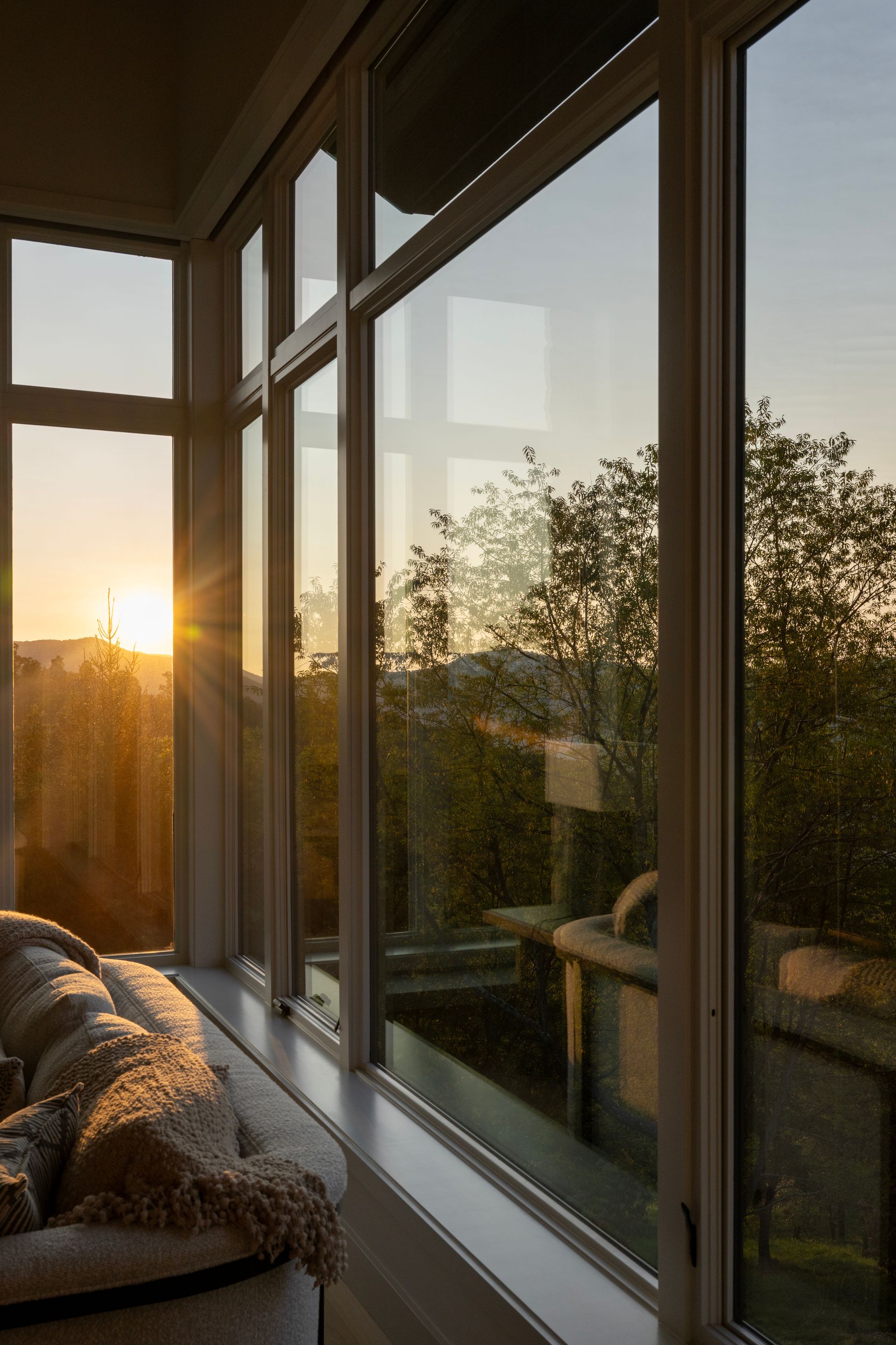 The sun is shining through the windows of a living room.