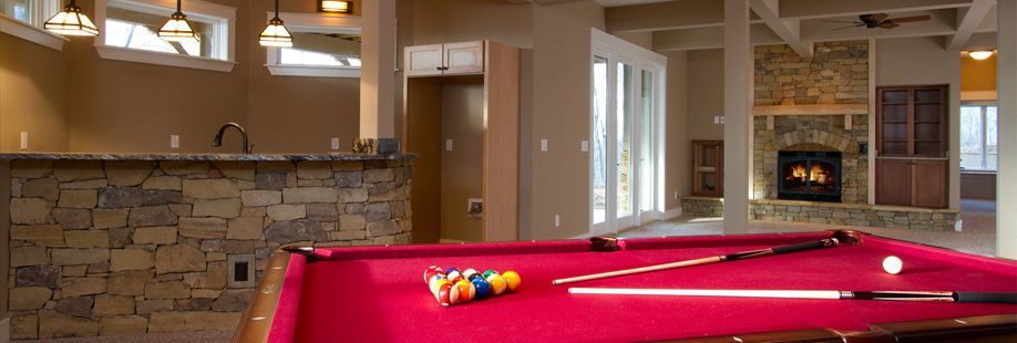 A pool table in a living room with a fireplace.