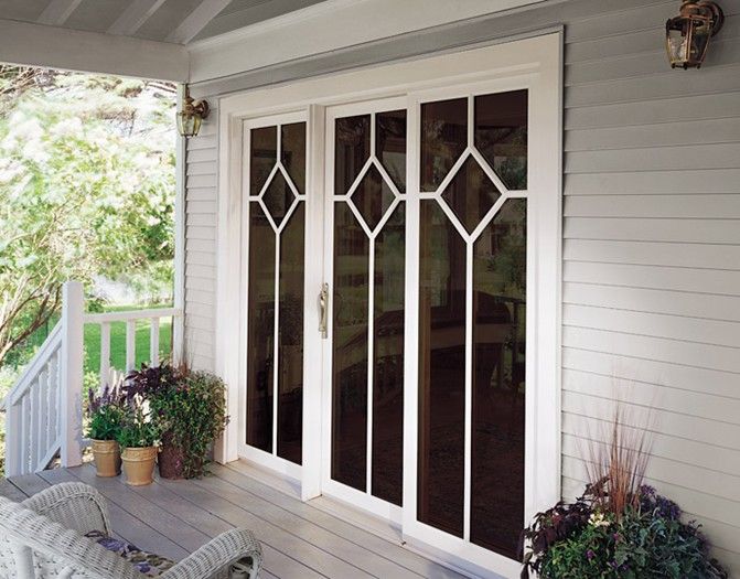 A porch with sliding glass doors and a wicker chair