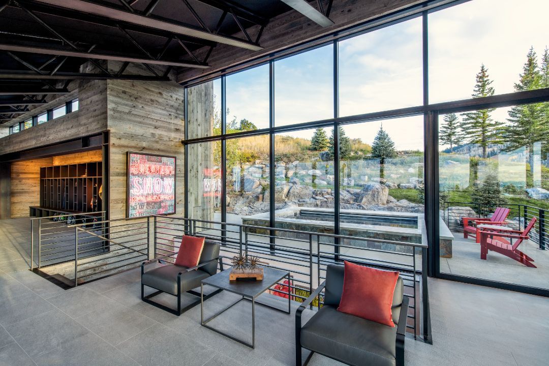 A living room with a lot of windows and chairs.