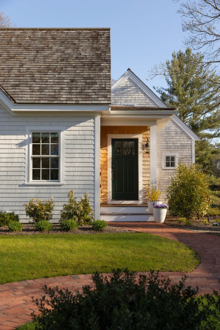 A white house with a porch and a black door