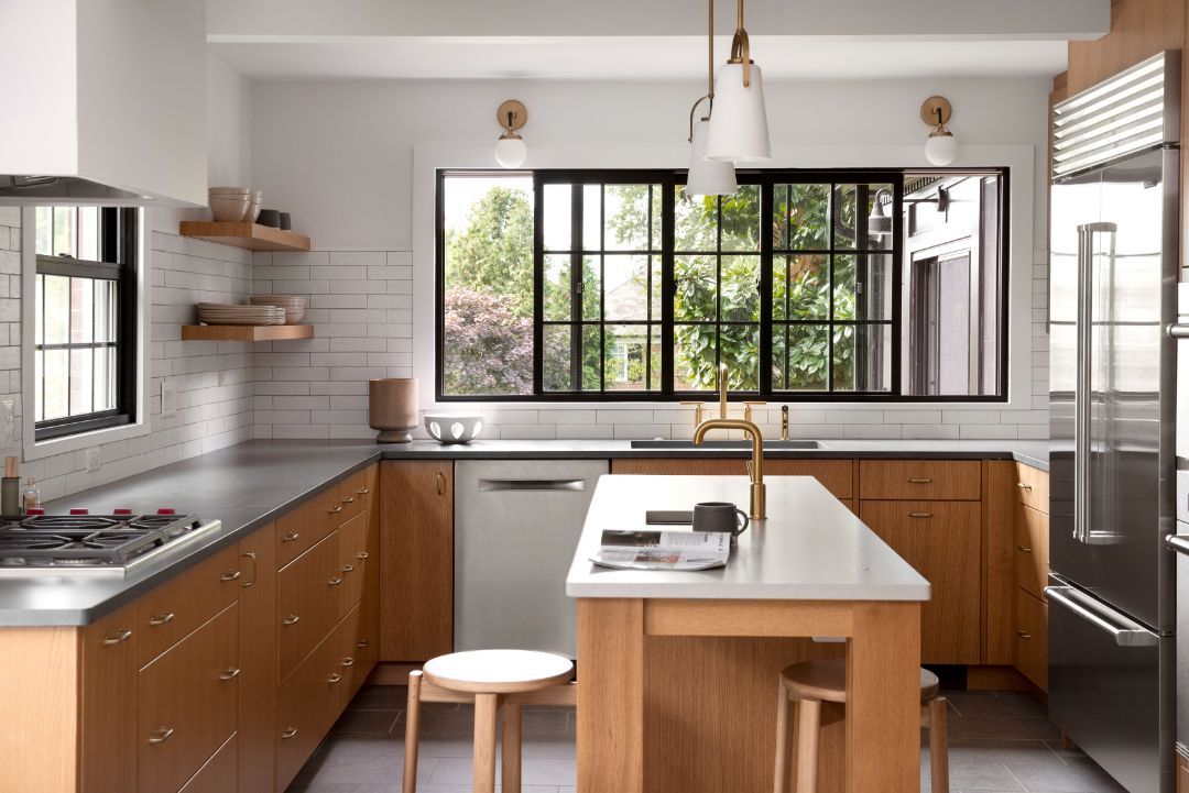 A kitchen with wooden cabinets , stainless steel appliances , and a large island.