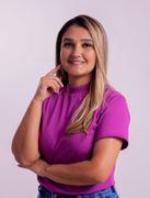 Mulher sorridente com blusa roxa posando contra um fundo claro.