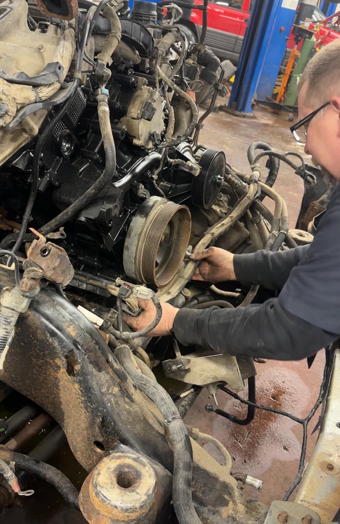 Engine Repair Technician Working On Vehicle | Leonard's Auto Service