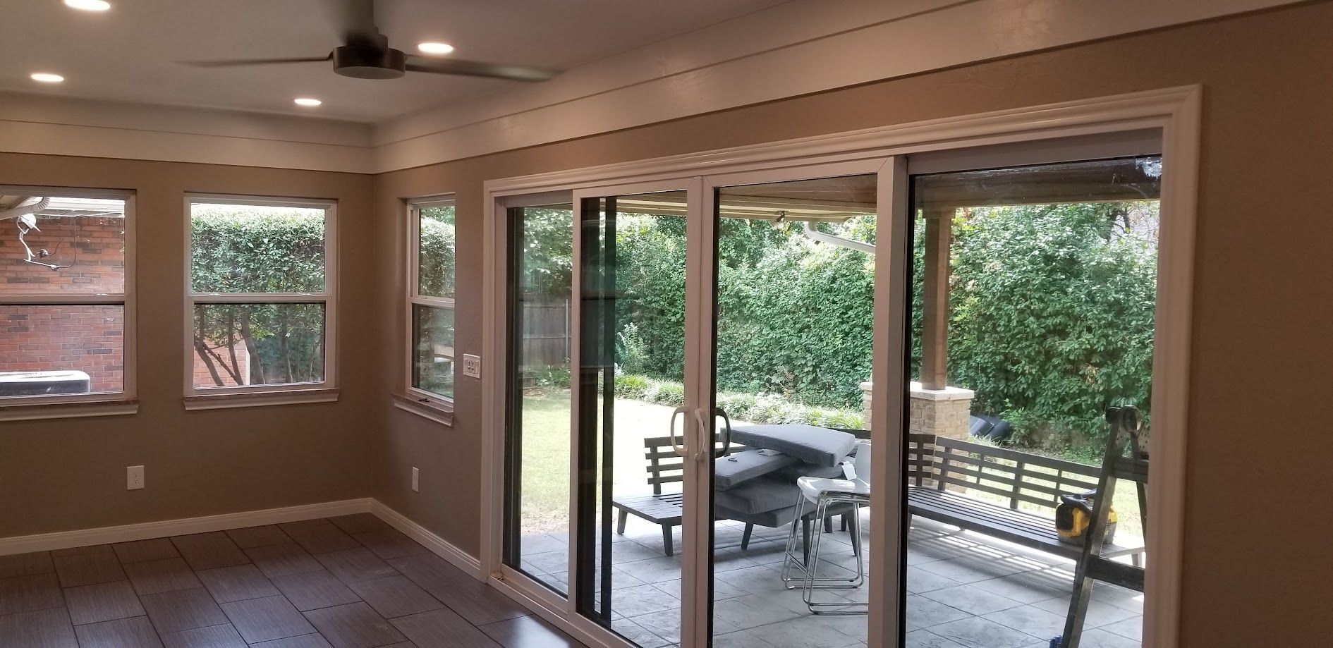 Living room with sliding glass doors opening to a patio and green backyard