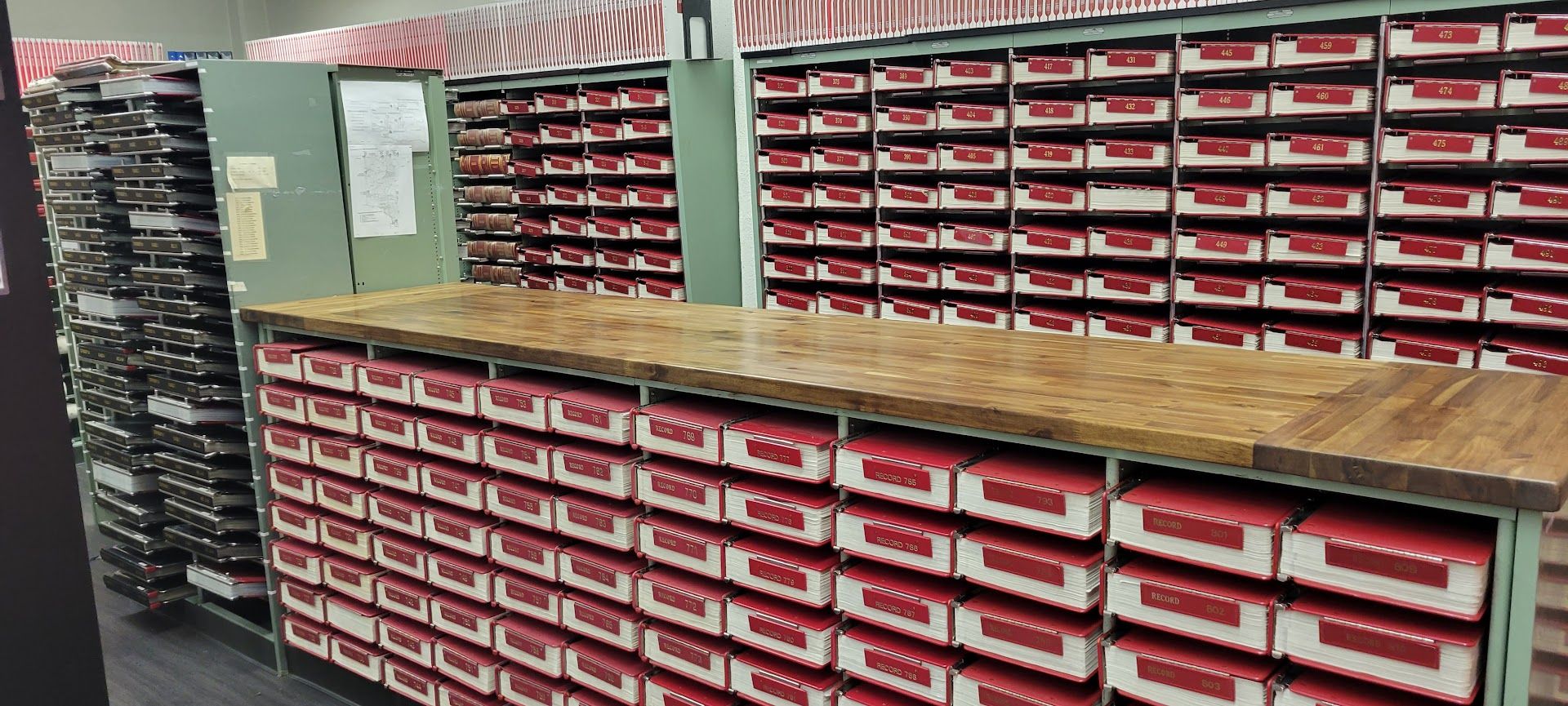 Shelves of small red-and-white storage drawers in a workshop or parts room