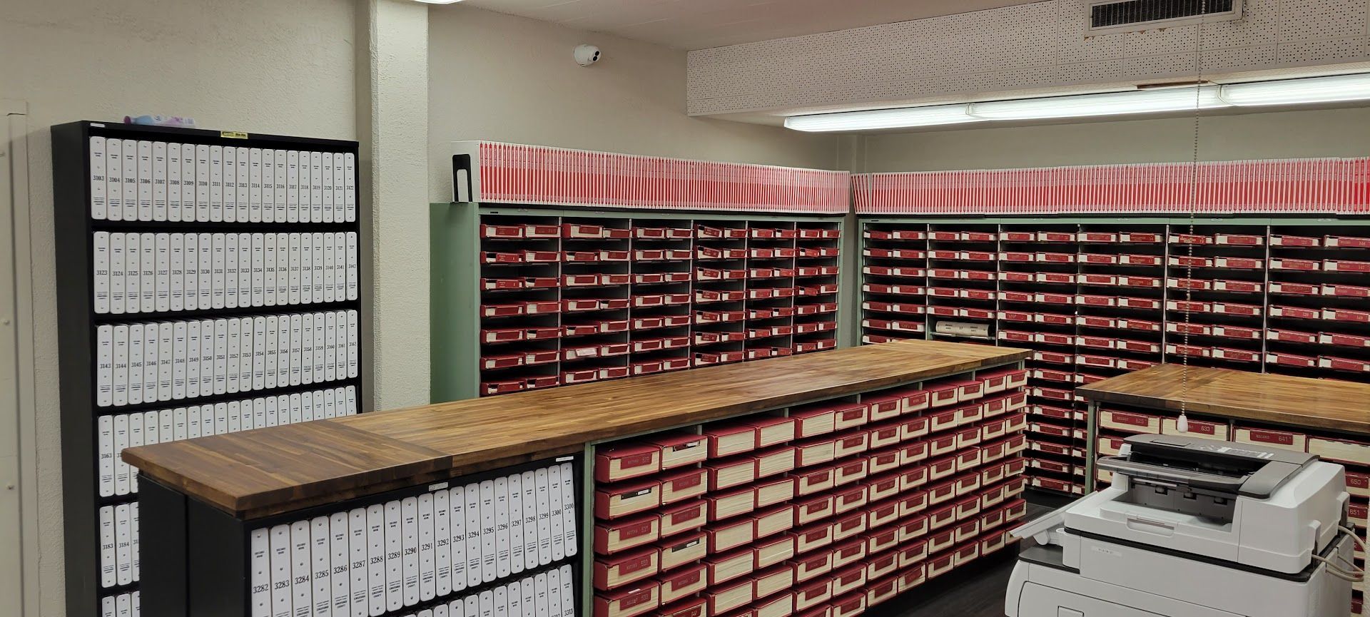 Post office mail sorting room with rows of cubby mail slots and stacks of sorted mail folders