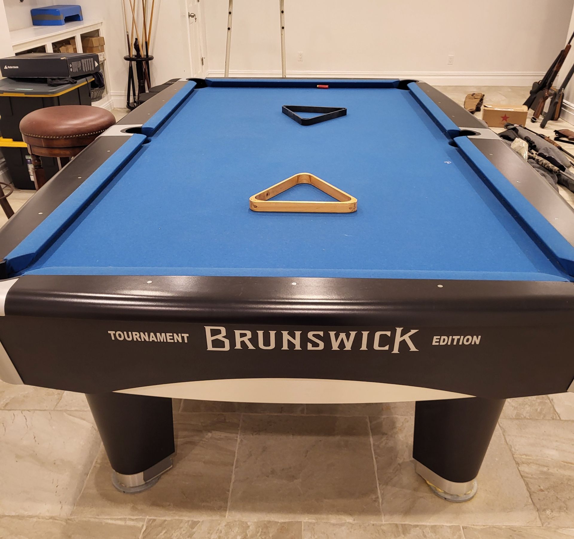 Blue Brunswick pool table in a room, with two triangular racks on the felt.