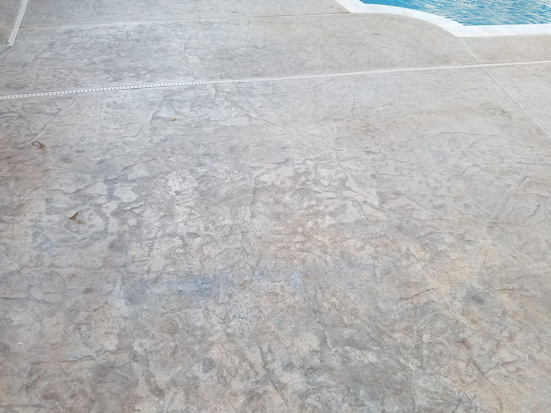 Close-up of a weathered gray concrete pavement with a white painted line near the top.