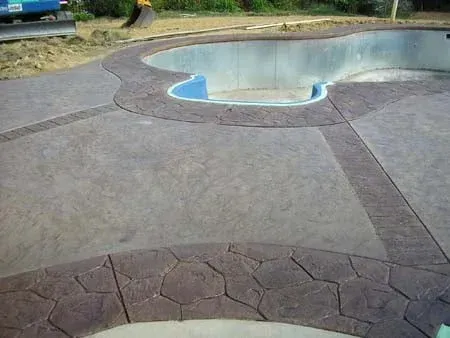 Empty outdoor swimming pool with a concrete deck and stone border