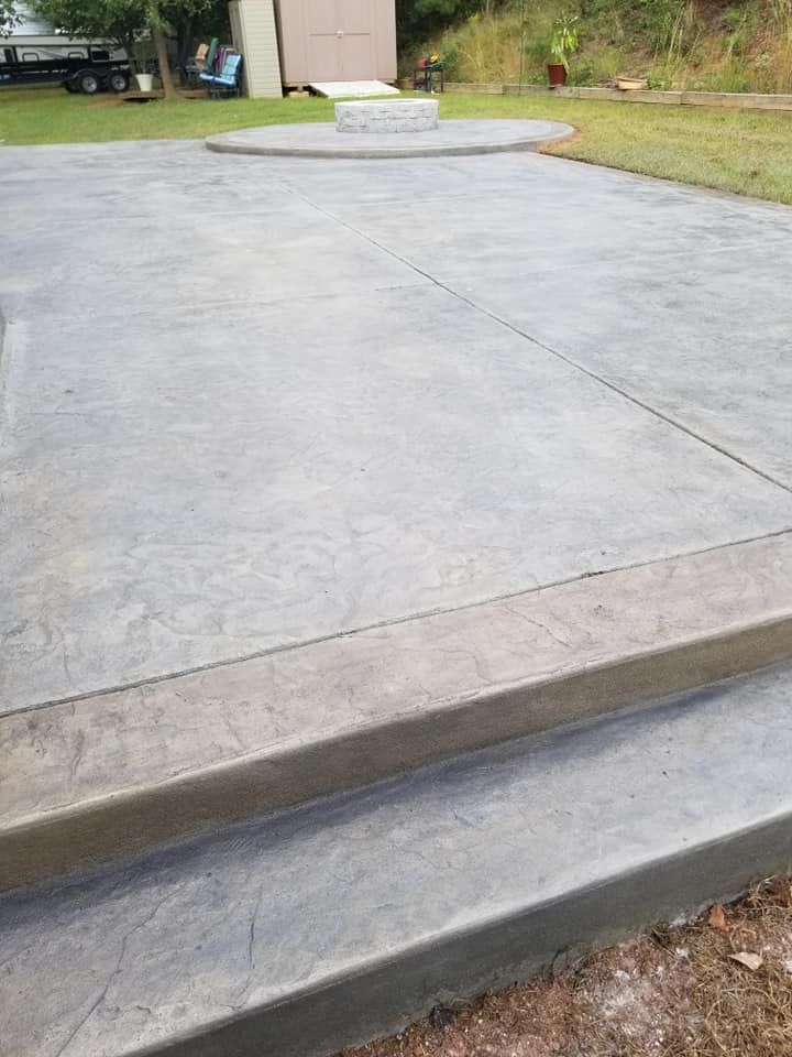 Concrete driveway with a curb ramp leading to a house in the background.