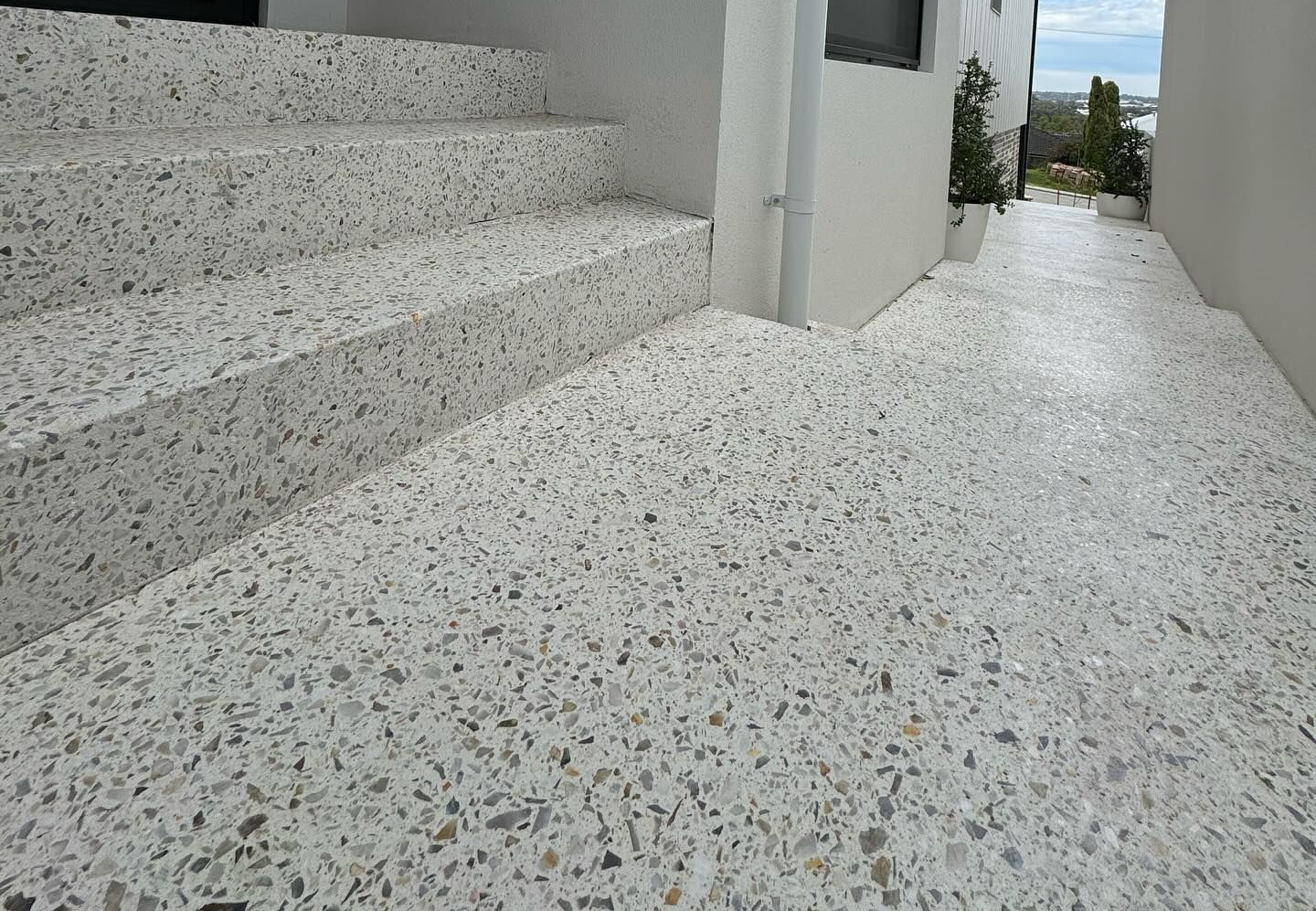 Amber white mix for a honed concrete entrance with stairs leading along the side entrance of the house.