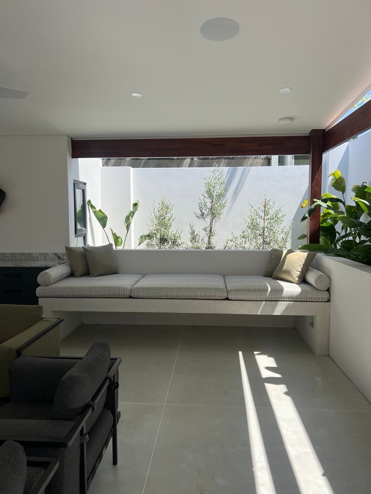 Architectural concrete day bed in concreted alfresco area flowing into backyard