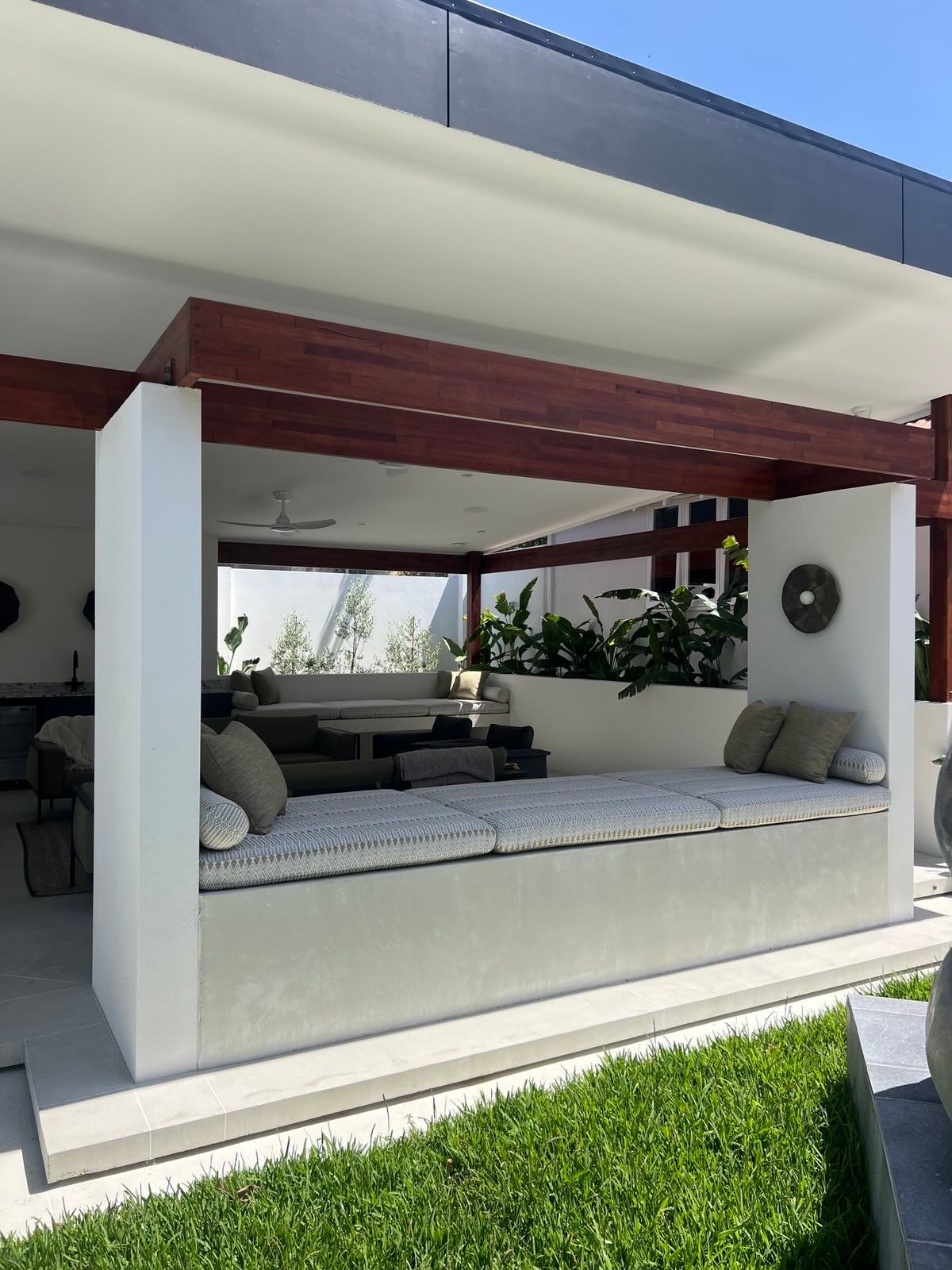 Outdoor concrete couch under patio area with transition into garden