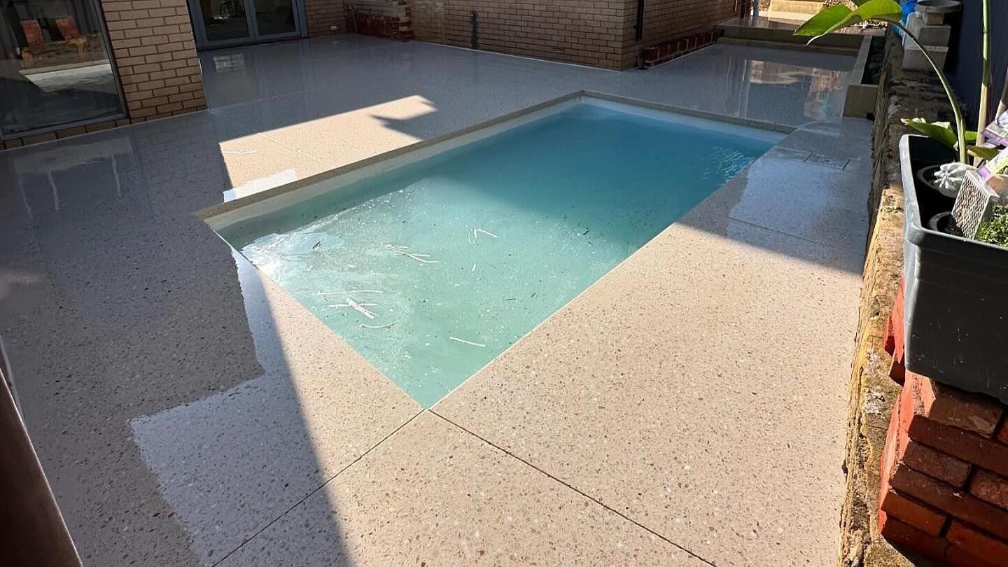Honed Concrete Pool Area surround with swimming pool with brick wall for house
