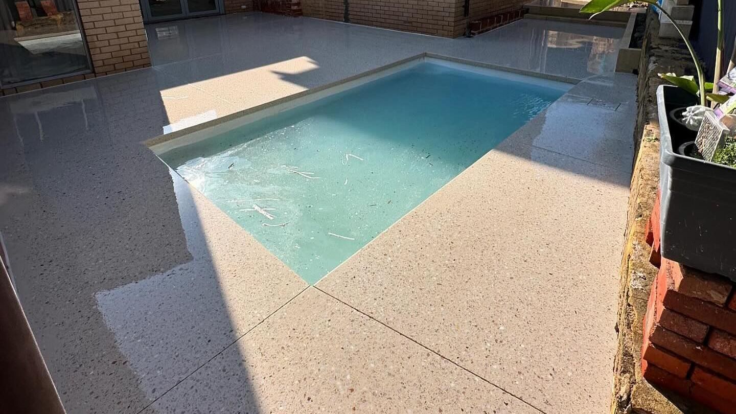 A small swimming pool in a Perth backyard with honed concrete pool surround.