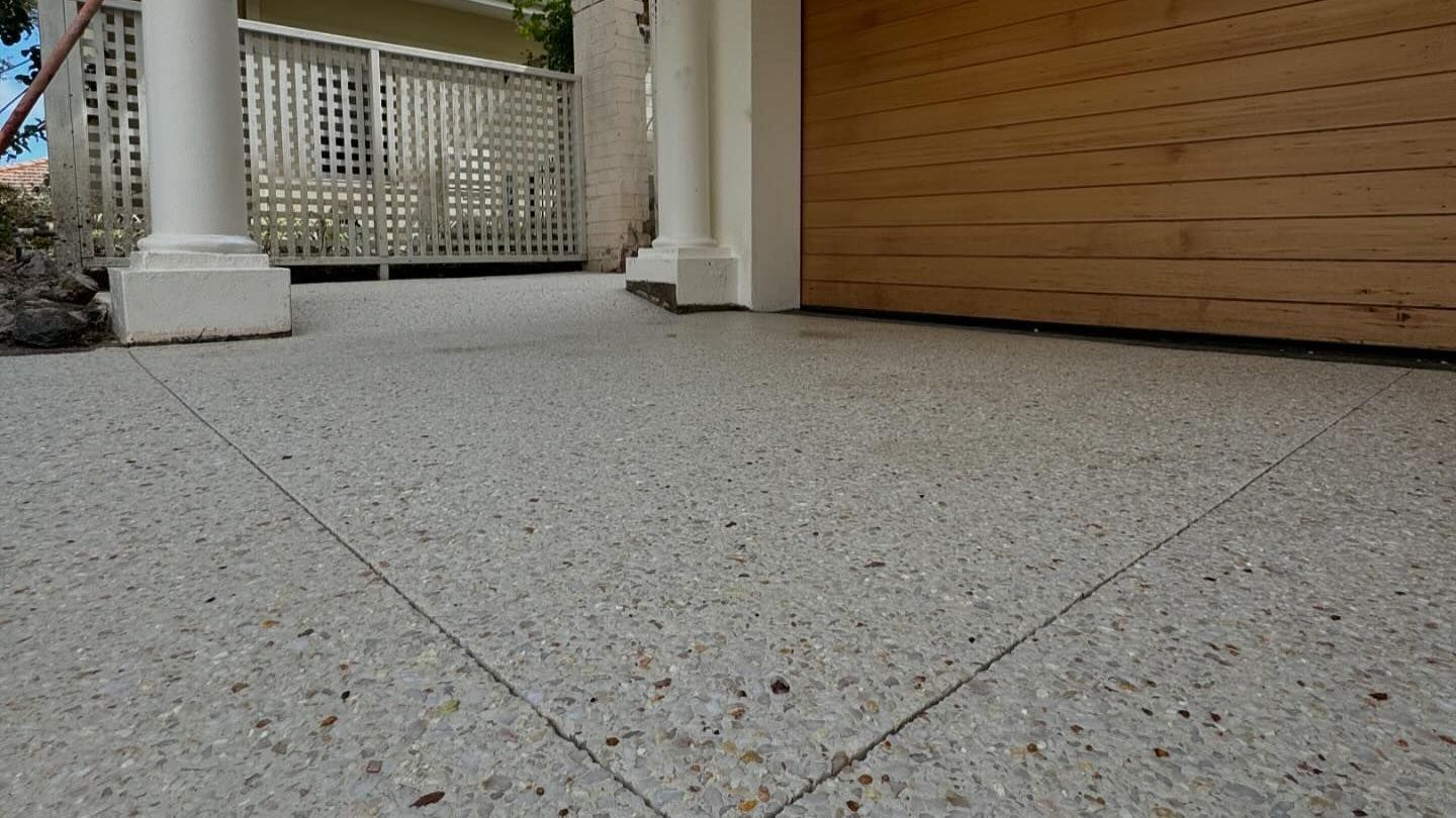 coral white exposed aggregate with wooden roller door and concrete pillar