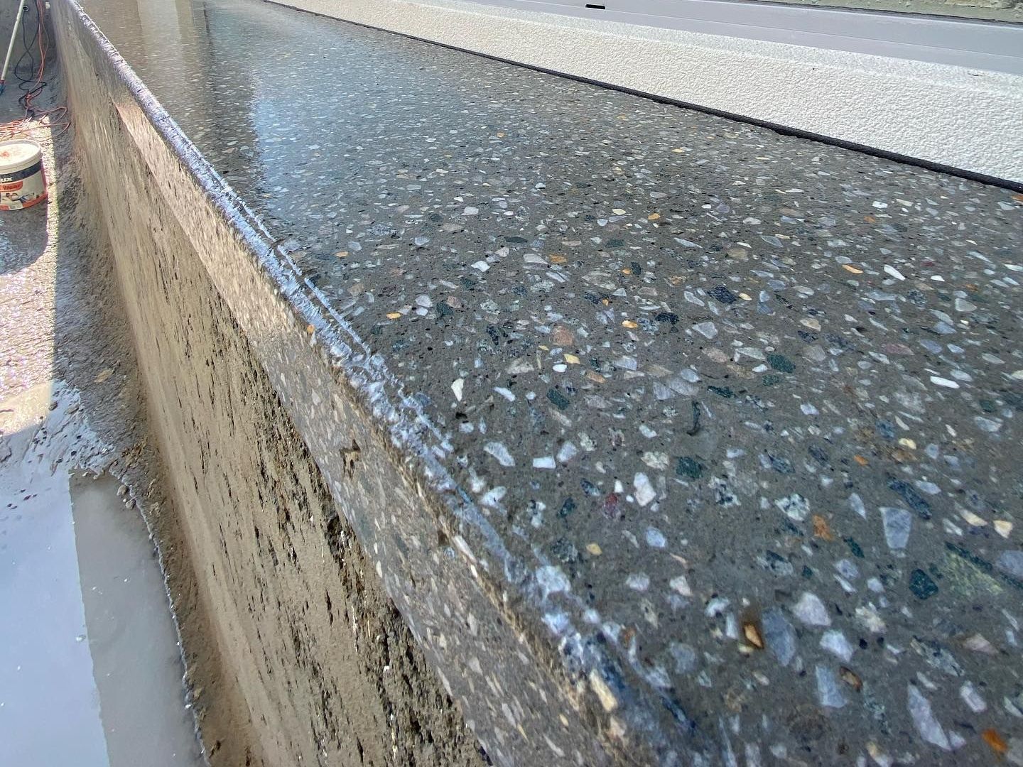 A close up of a honed concrete pool edge